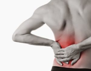 Rear view of a young man holding his back in pain, isolated on white background